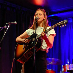 Julie Title performing with a guitar