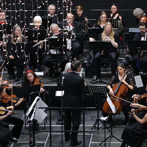 View of an orchestra performing on a stage.