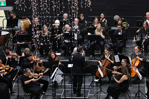 Overhead view of an orchestra performing on a stage.