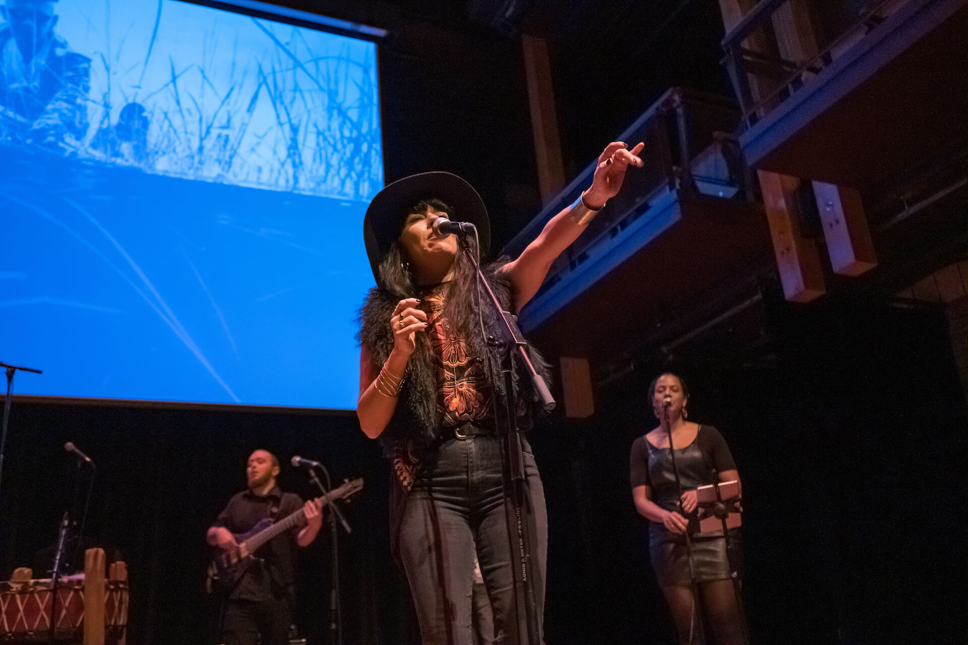 ShoShona Kish (centre) of Digging Roots performs during the Gchi Dewin Indigenous Storytellers Festival at the Charles W. Stockey Centre for the Performing Arts in Parry Sound, a co-presentation by MUSKRAT Magazine and ReZ 91.3 FM. (Photo: Robert Snache) 